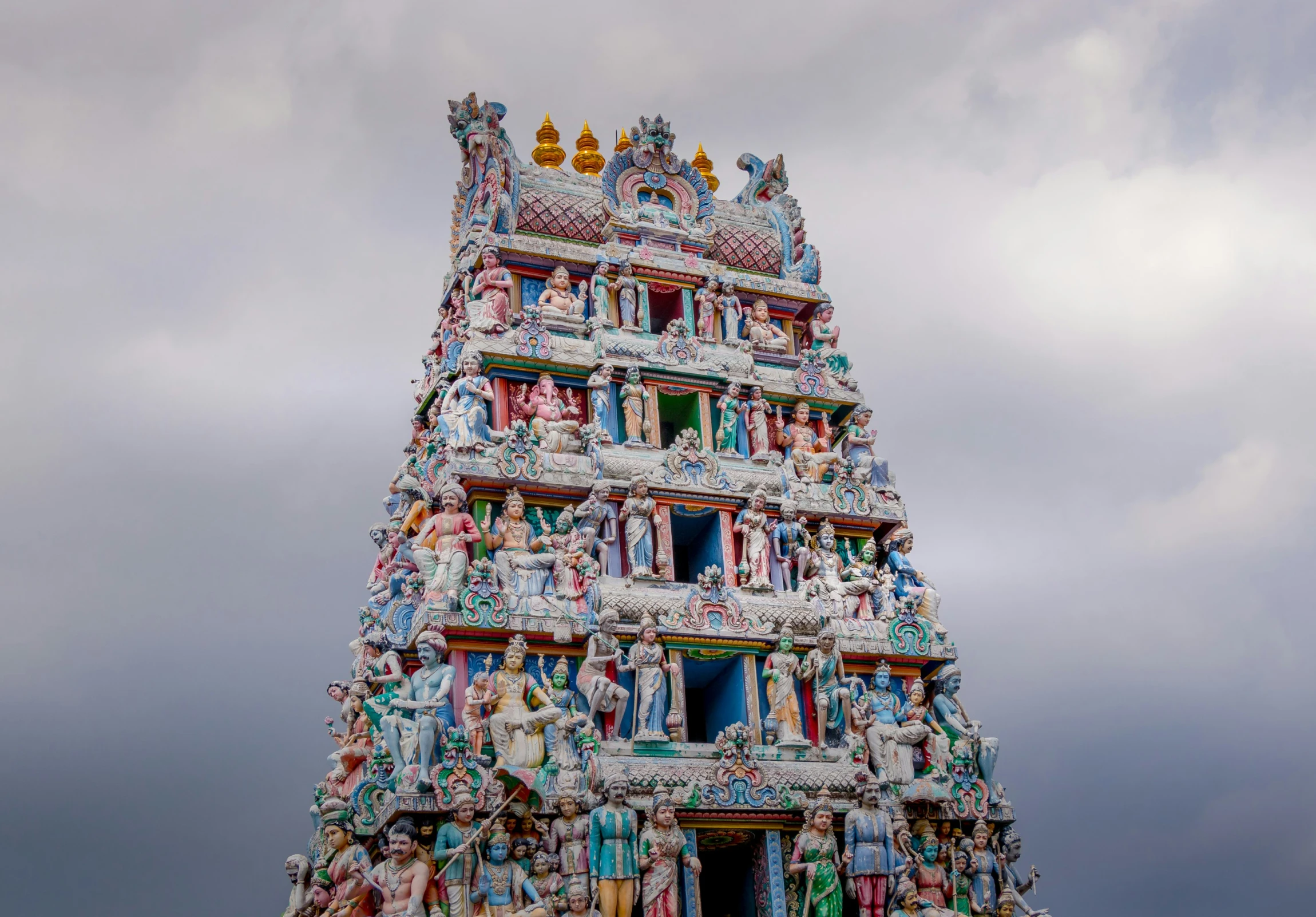 a multi colored tower with statues on it