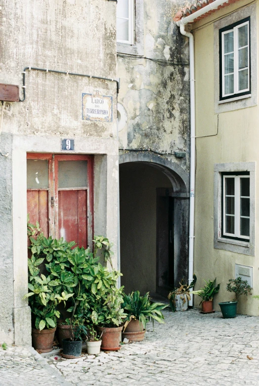 a courtyard next to a building with potted plants