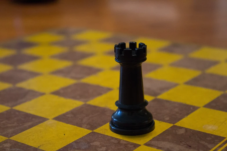 a small plastic black chess piece on the ground