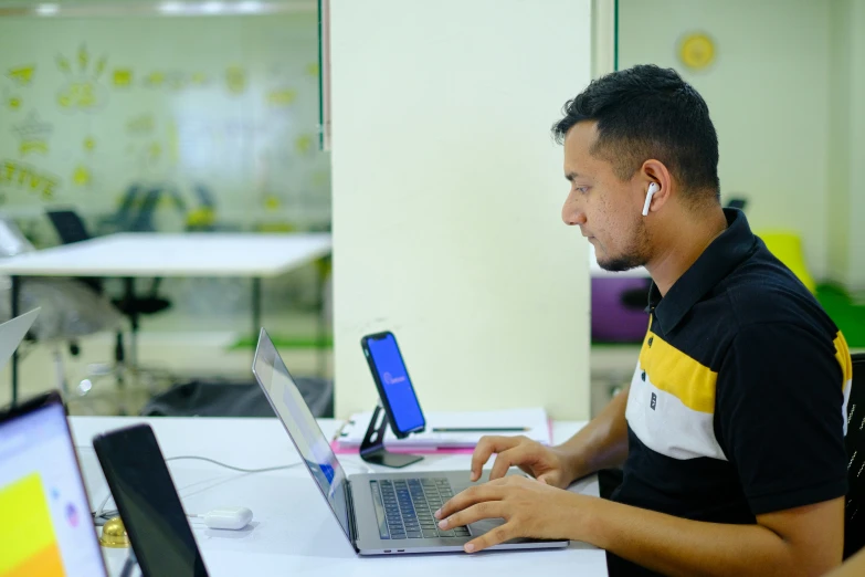 a man sitting at a table in front of a laptop