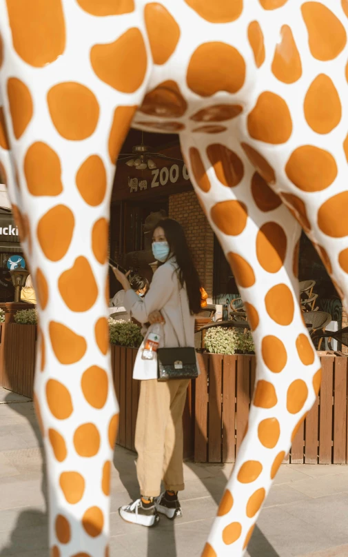 an inflatable giraffe has been decorated with the face of a woman with a medical mask