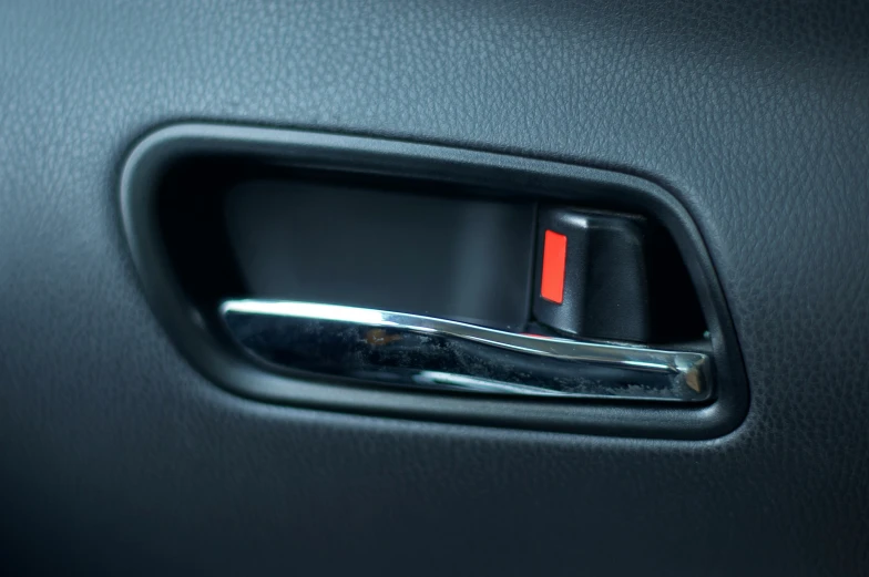 a red and white box on the front door handle of a black car