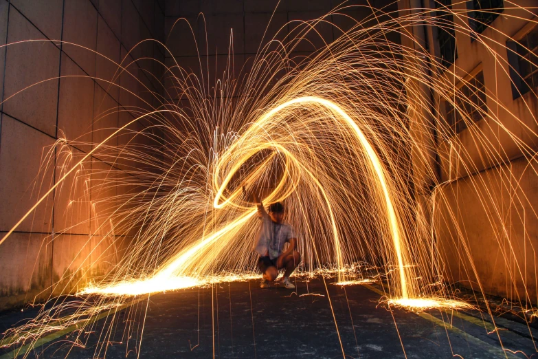 a man bending down in front of some fire works