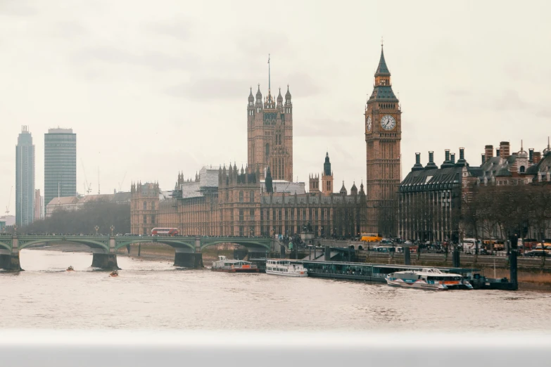 a river with boats in it with two large tall buildings on one side and a bridge in the other