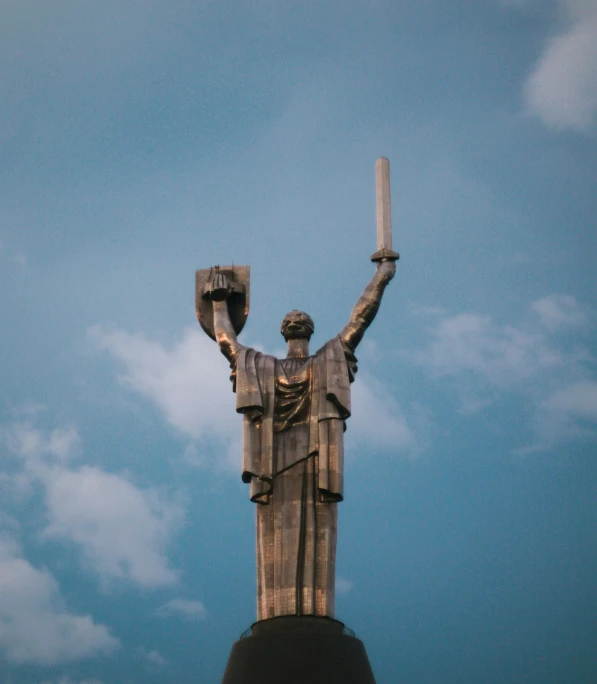 a statue stands tall with a lit up candle in her hand