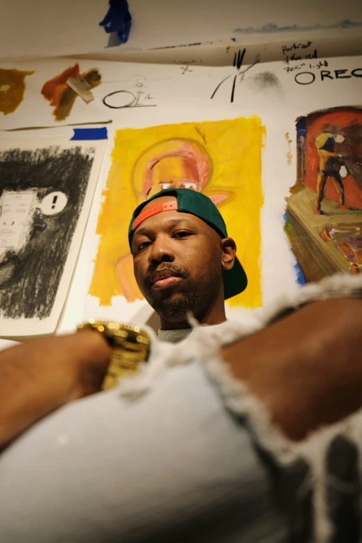 a man standing in front of some paintings