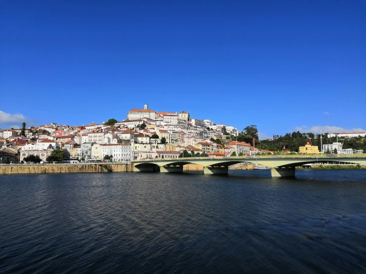 bridge and buildings on river with blue sky
