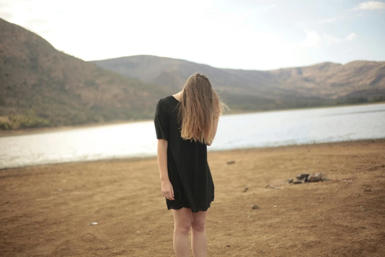 a girl with her hair back facing water