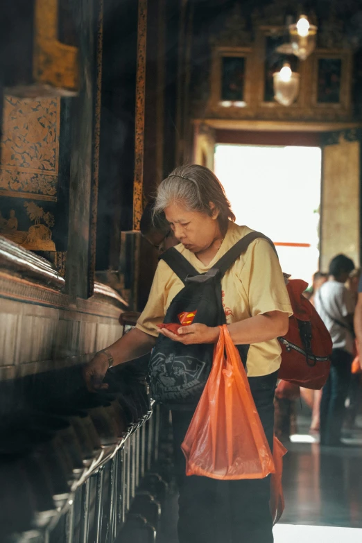 an old woman is on a subway using a cellphone