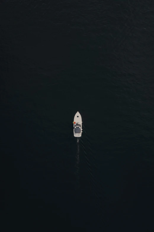 the small boat floats in the deep water