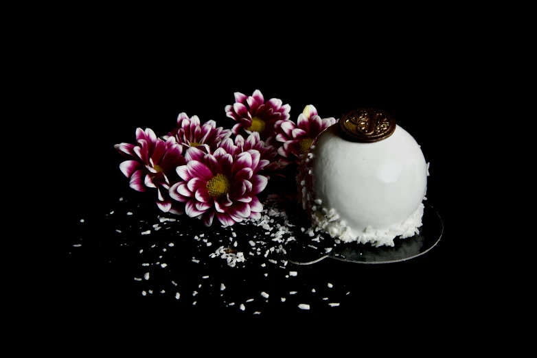 a cake sitting on top of a white plate surrounded by flowers