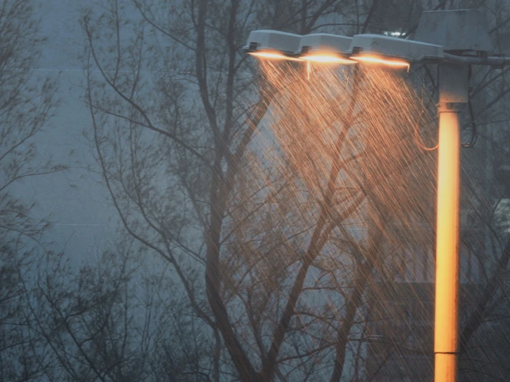 three lamps on the side of the road in the rain