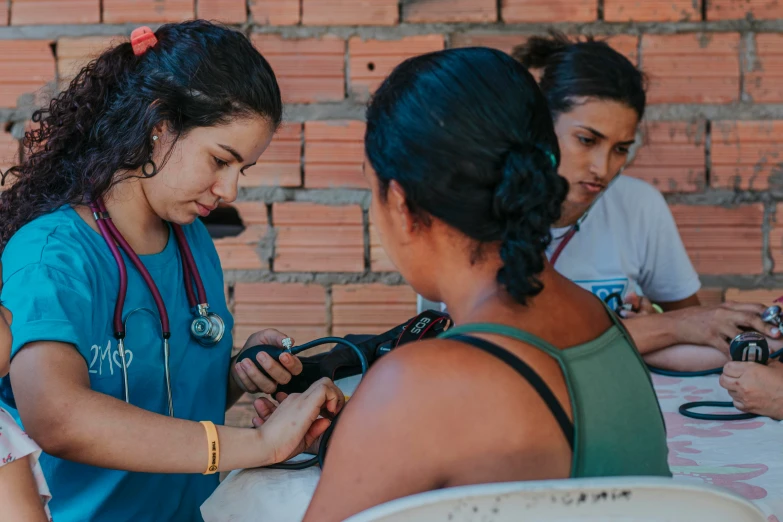 a person with stethoscope examining another persons'heart