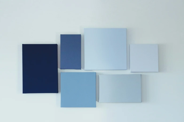 several different shades of blue sit on a white surface