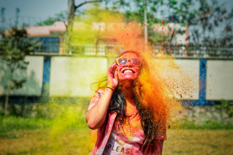 a girl in pink is covered with yellow powder