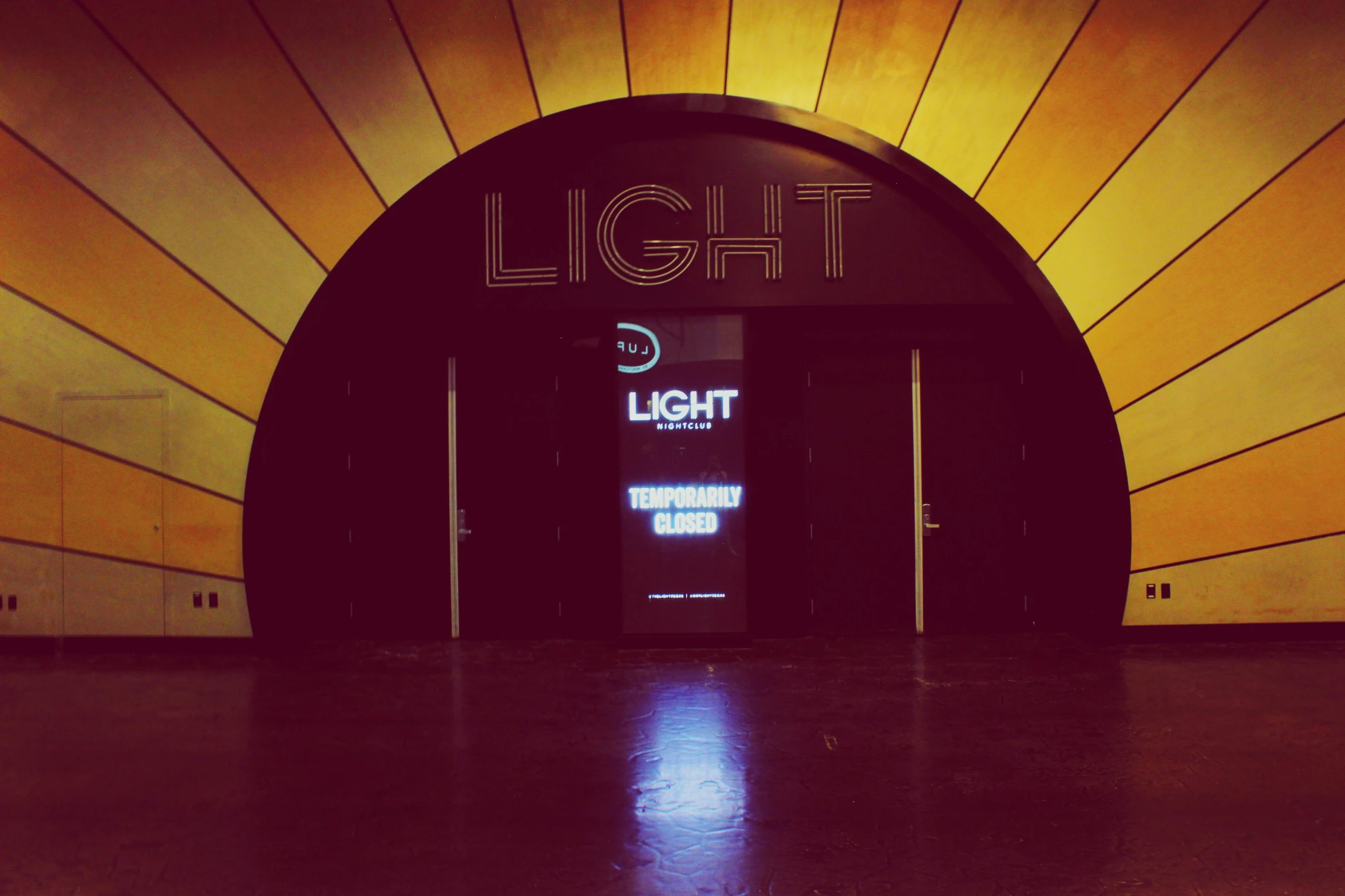 a black door sits in front of a lit light store