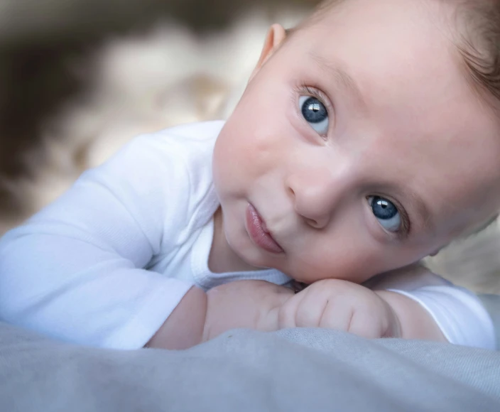 a baby with blue eyes and an intense look