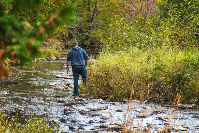 a man fishing from the shore of a river