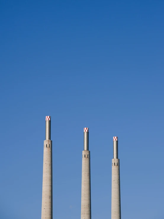 three chimneys standing on top of a stone platform