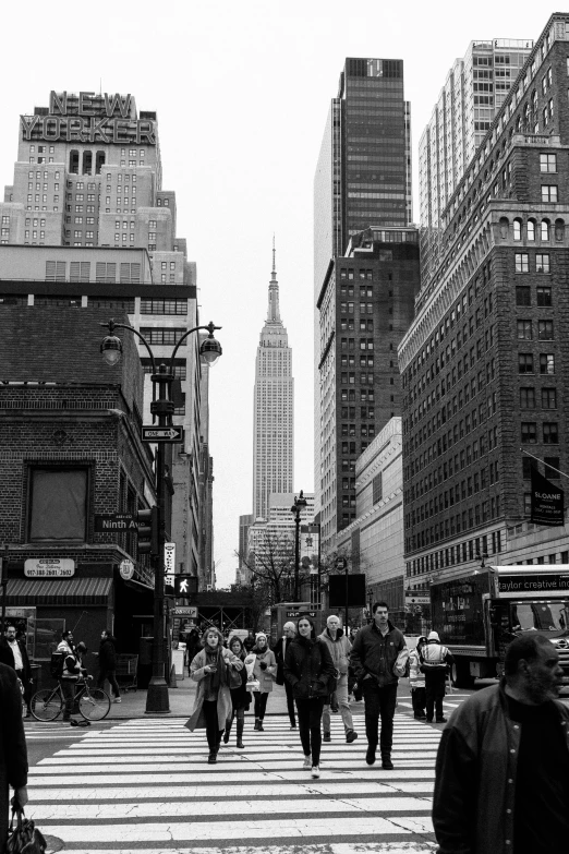 people walking across the street in a city