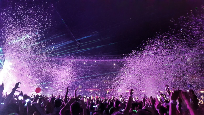 a stage filled with confetti and a huge crowd watching