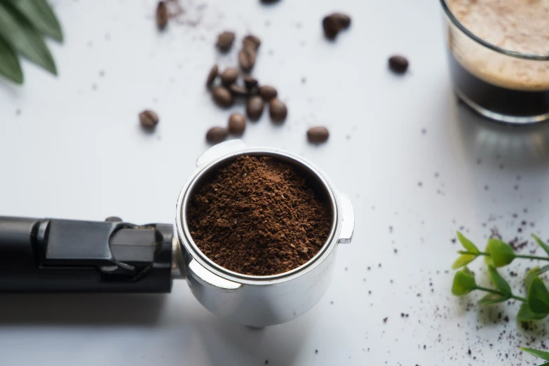 a coffee mug with ground coffee, on a table