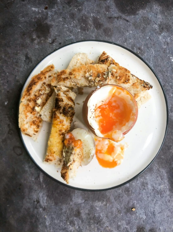 two eggs in toast and sausage on a white plate