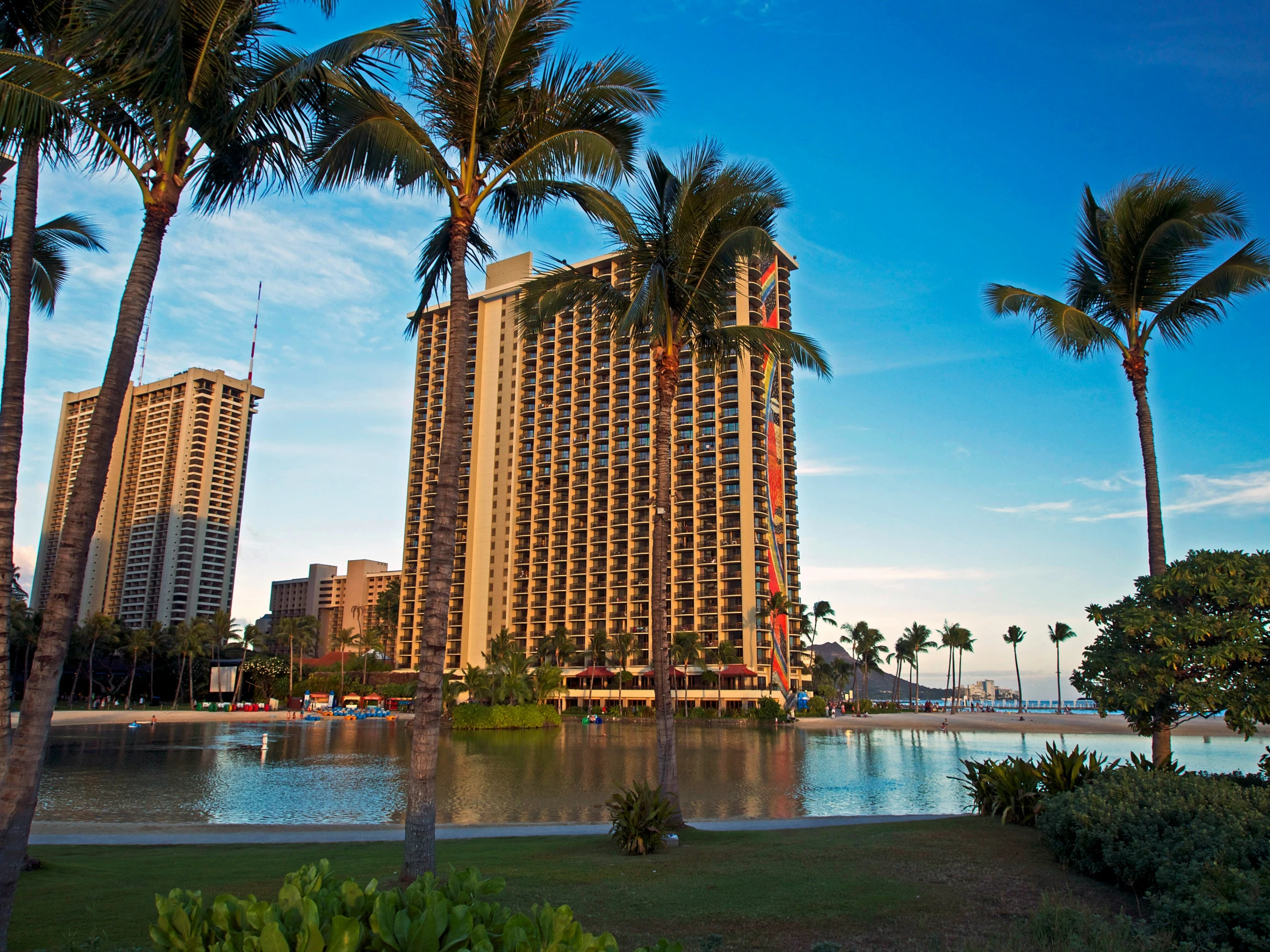 the palm trees are near the building by the ocean