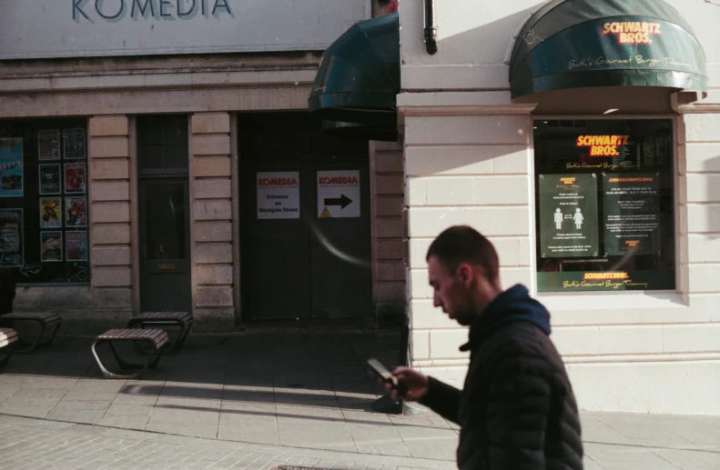 a man looking at his phone on a sidewalk