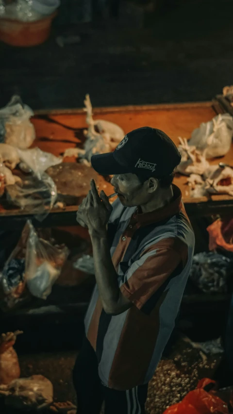 a man wearing a hat standing by his food