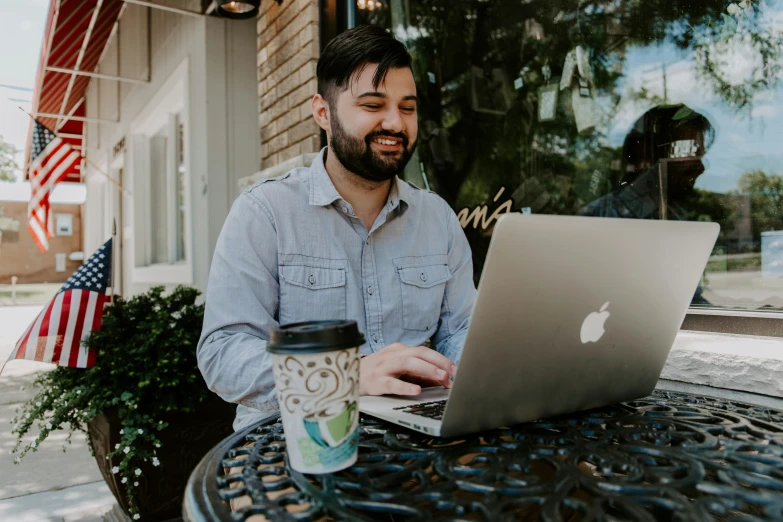 a man sitting in a chair looking at his laptop