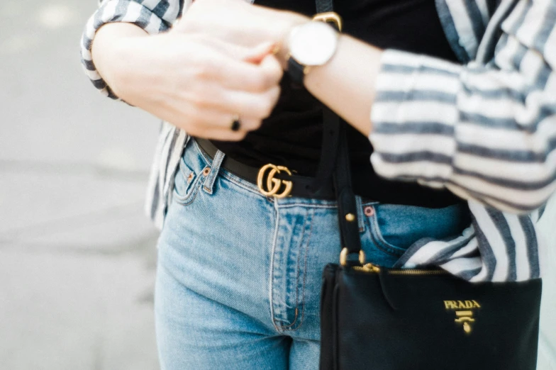 woman wearing an open shirt and holding a black purse