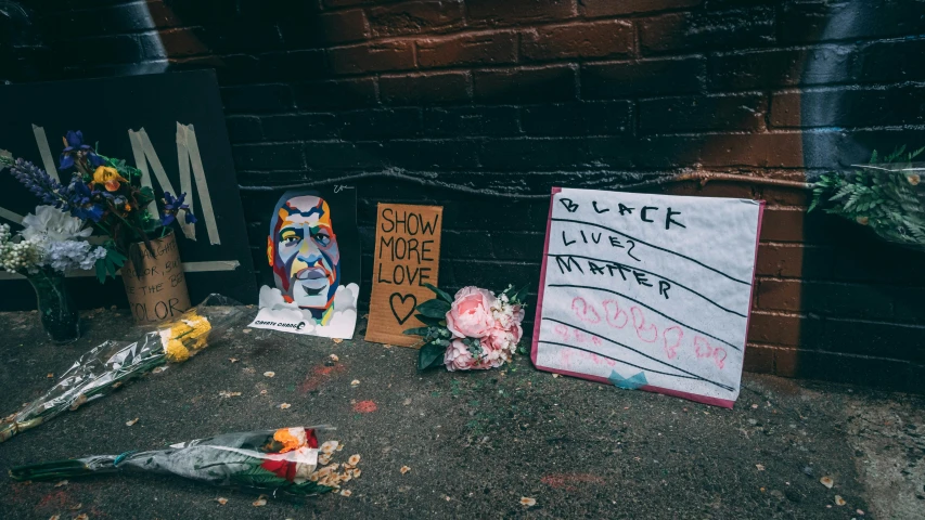 flowers, candles and pictures are sitting on the sidewalk