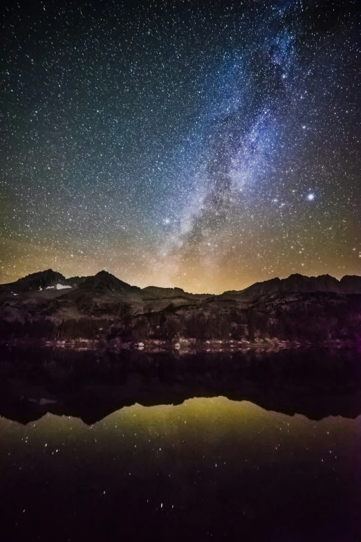 a night sky with a lot of stars and the stars reflecting on the water