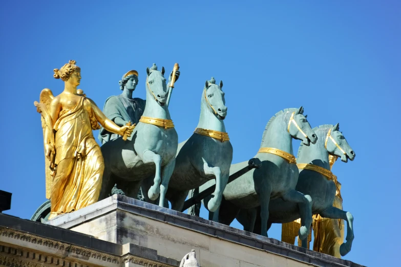 a row of horses standing next to the statue