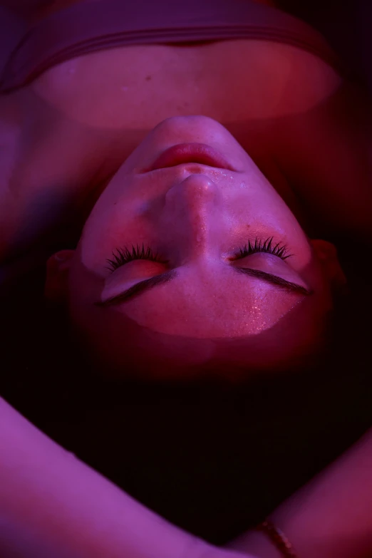 a woman with eyelashes is laying down