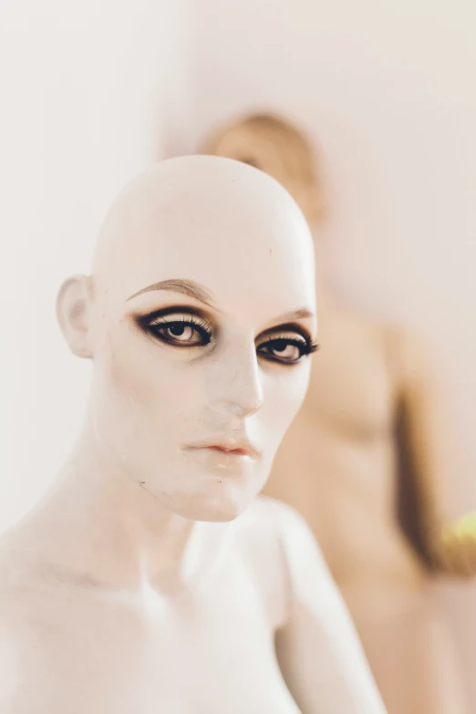 a female mannequin is standing in front of an orange object