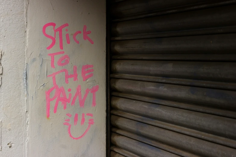 graffiti writing on a wall near a garage door