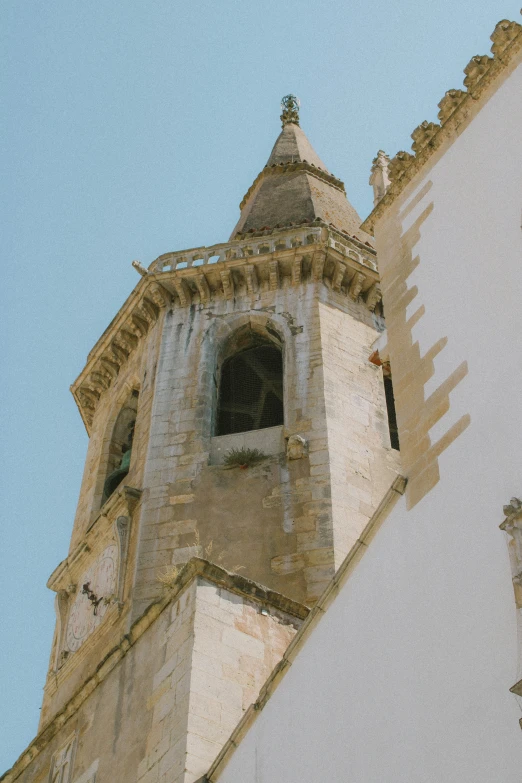 a tall white tower with a bell on top