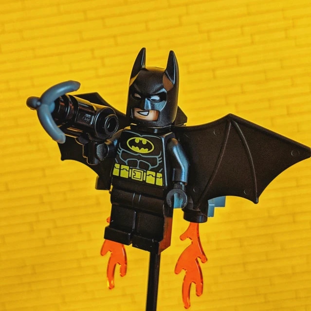 the lego batman figure poses with his arm outstretched