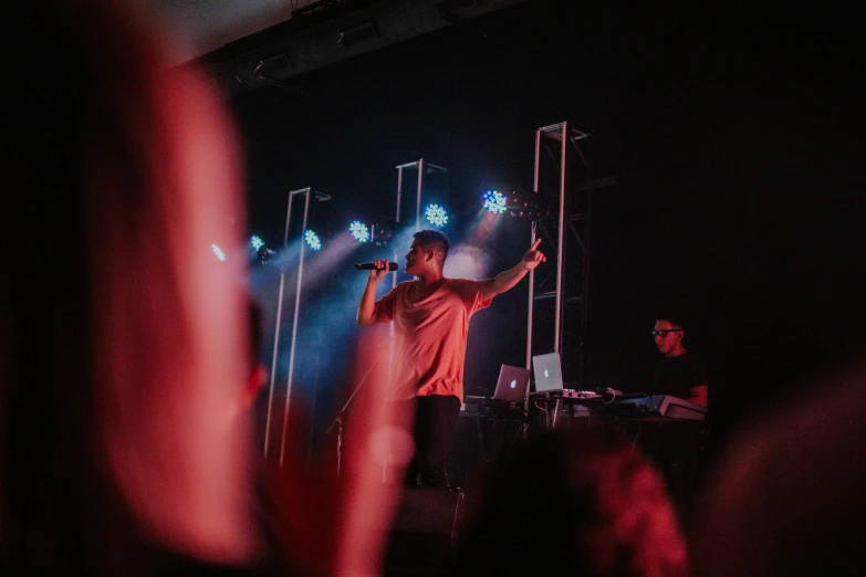 two people holding up microphones standing on stage