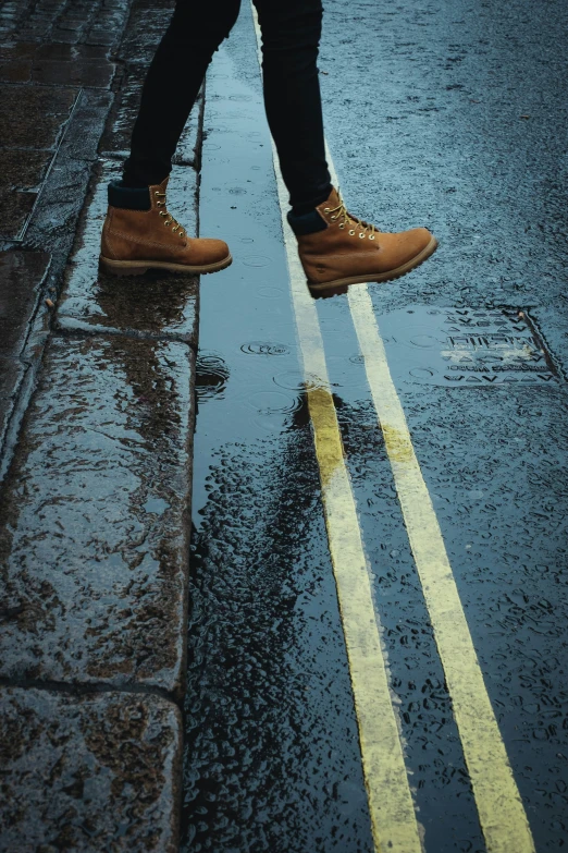 a pair of shoes standing in the rain on a street