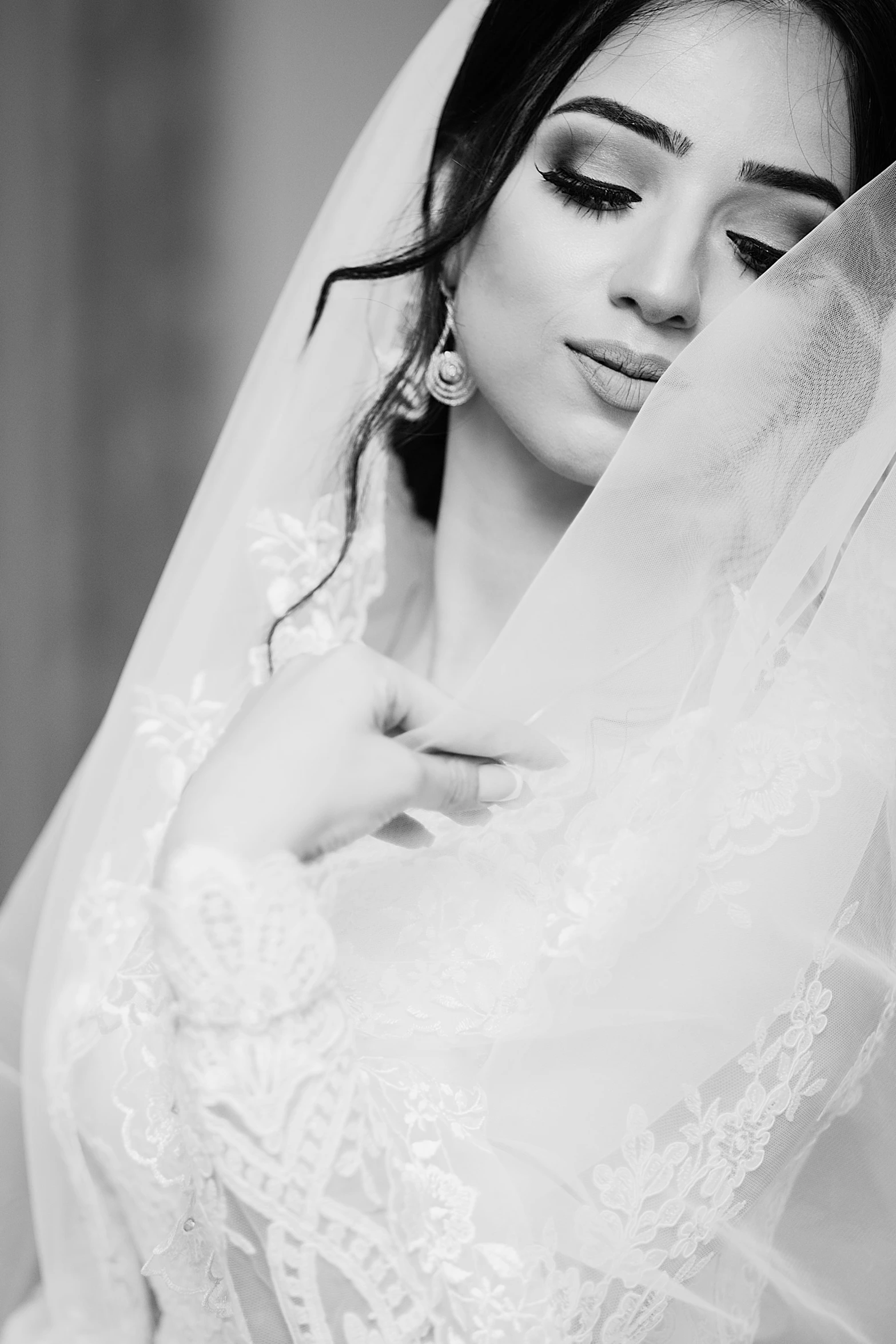 black and white image of a bride holding the veil