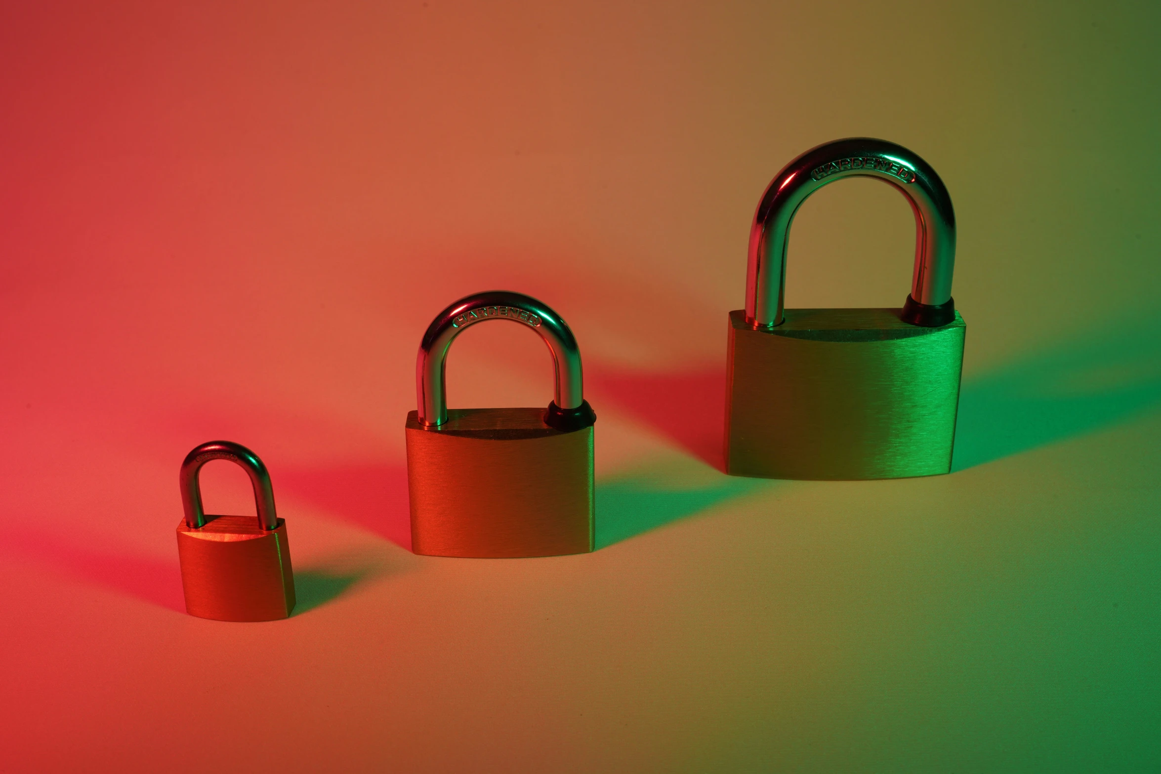 two open padlocks sitting side by side in front of a colored backdrop