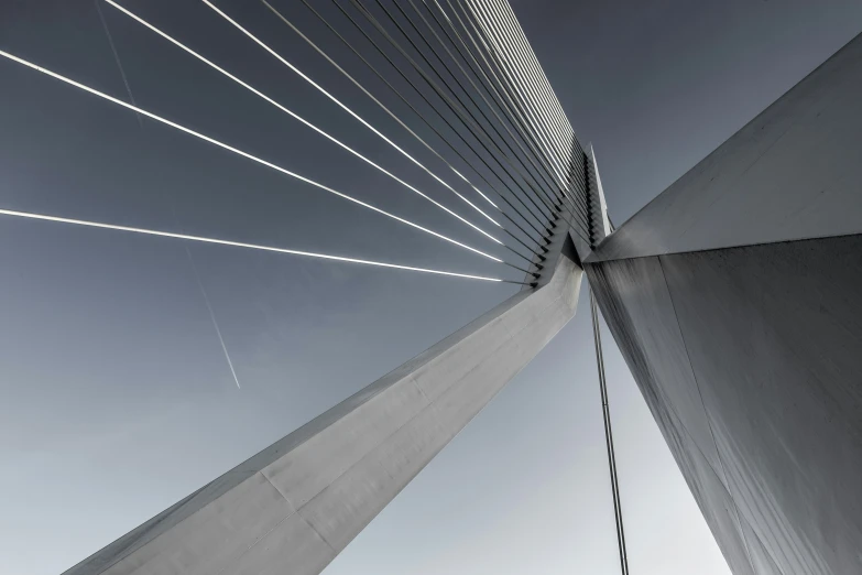 the view from under a tall bridge with lines on the bridge