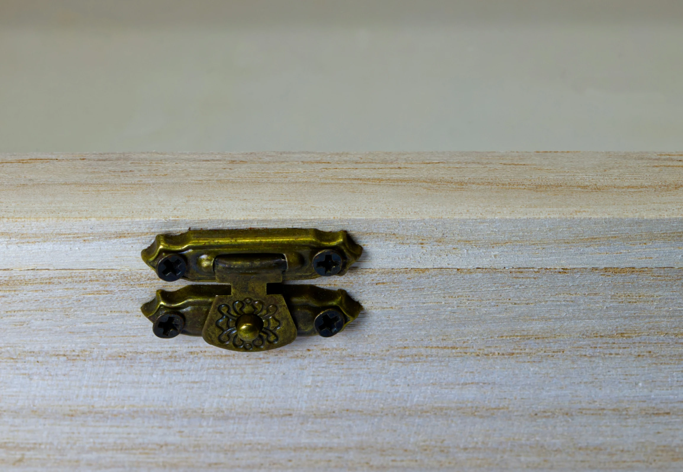 a small gold colored object laying on top of a wooden counter