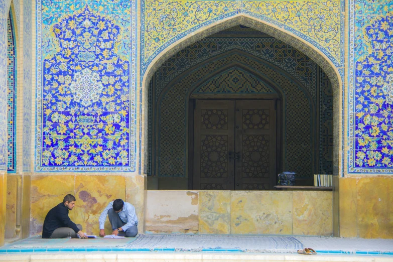 two women sitting by a door looking at soing