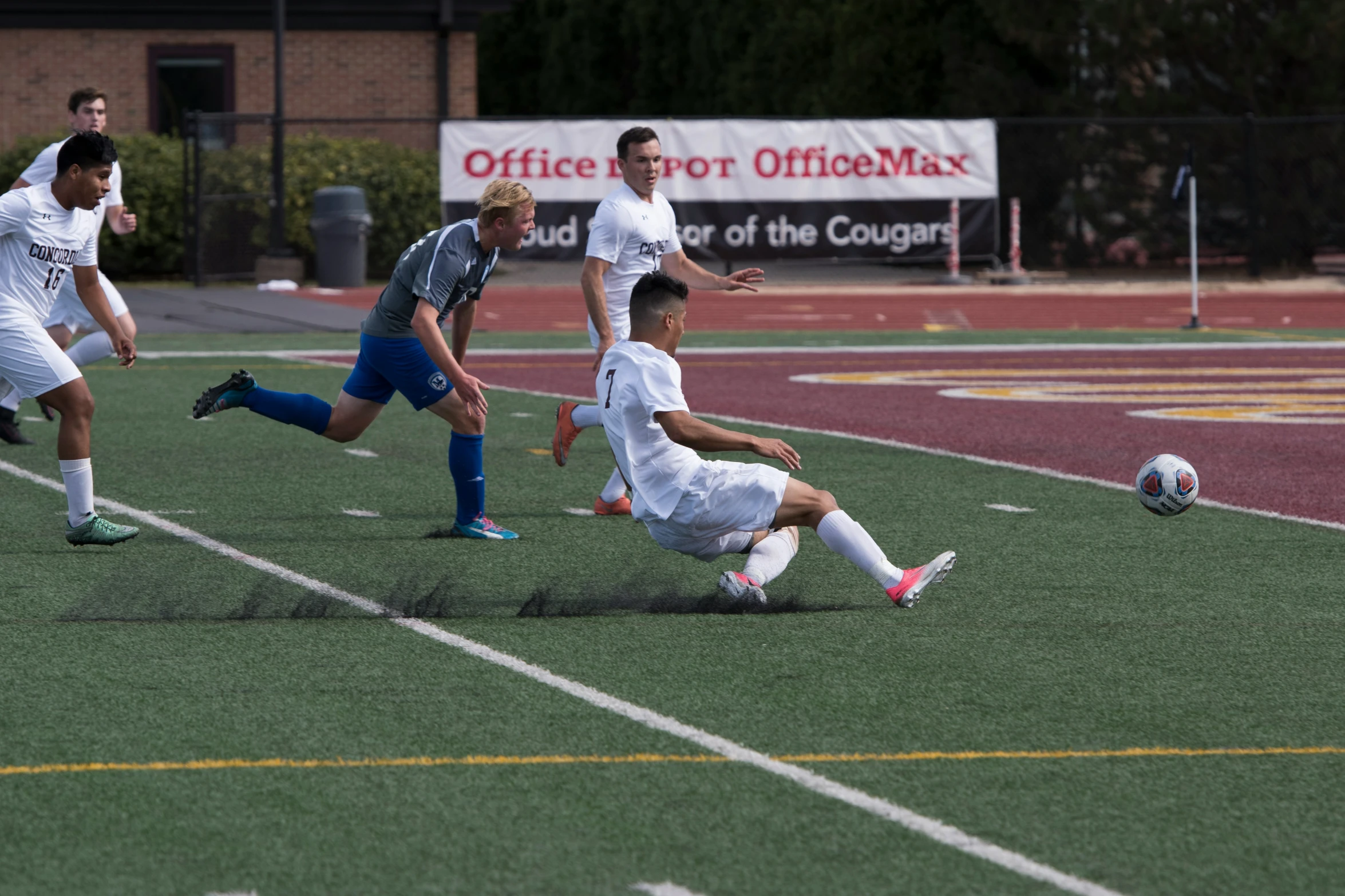 two teams playing soccer while three people watch