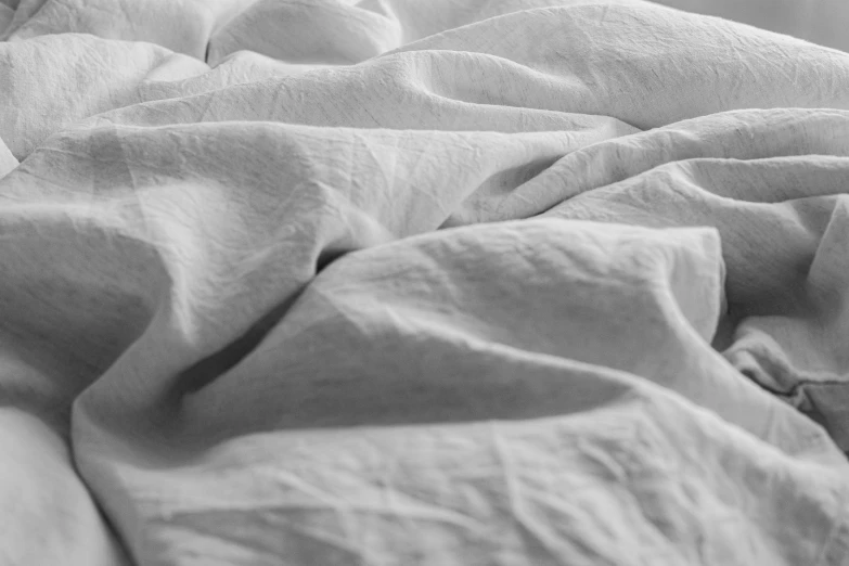 a closeup of a bed with white sheets and covers