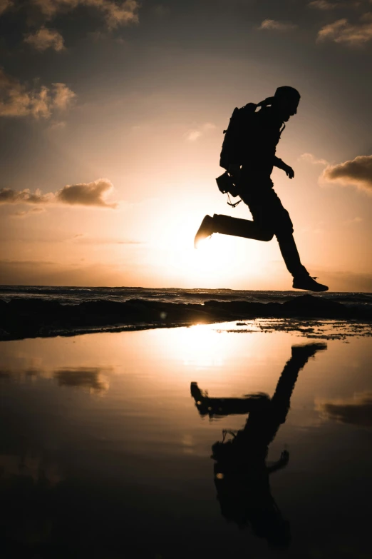 a person jumping up into the air on a beach